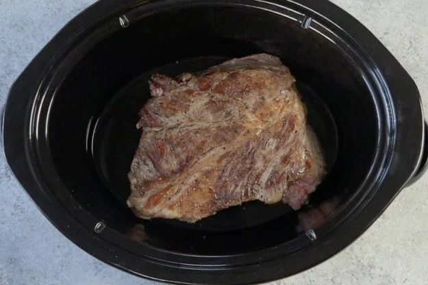Roast placed in slow cooker.