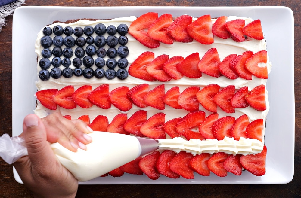 Piping frosting between strawberries.