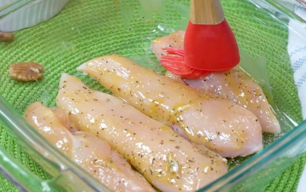 Brushing chicken with honey/mustard mixture.