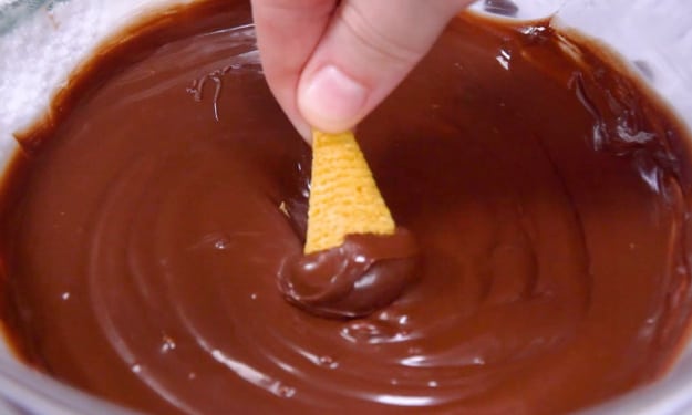 Dipping bugles in chocolate.