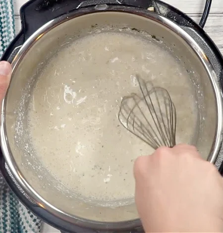 Whisking the sauce.