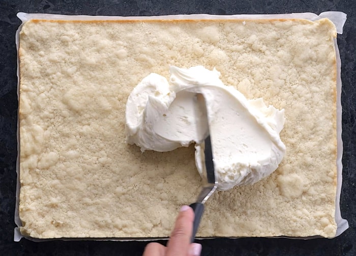Spreading frosting on.