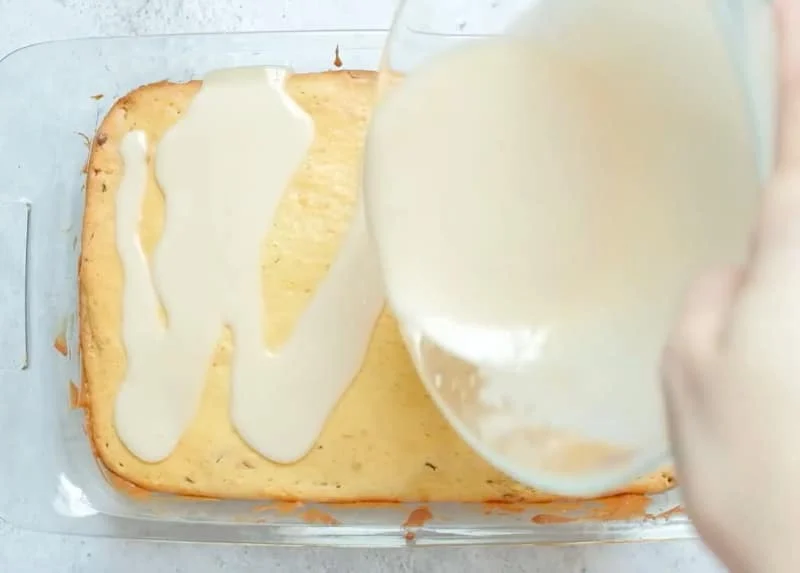Glaze being poured on cake.
