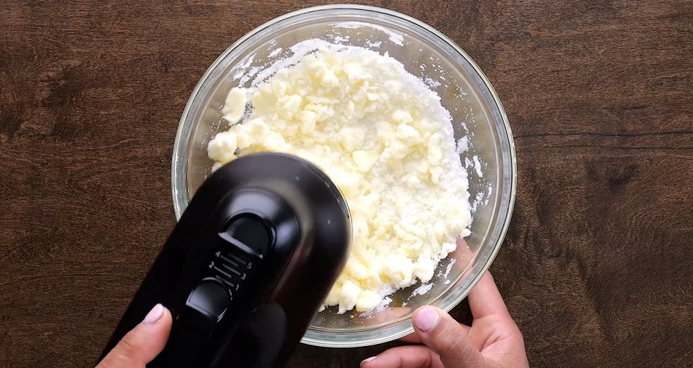 Beating butter and sugar with electric mixer.