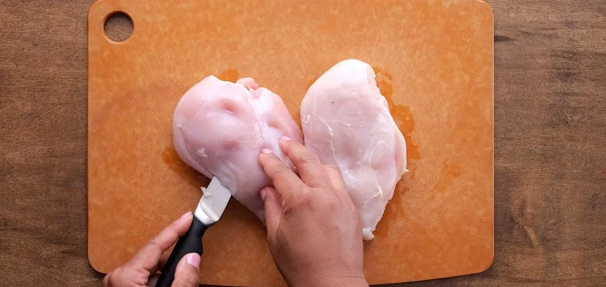 Cutting pockets in chicken breasts.