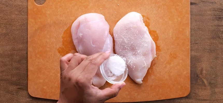 Seasoning the chicken.