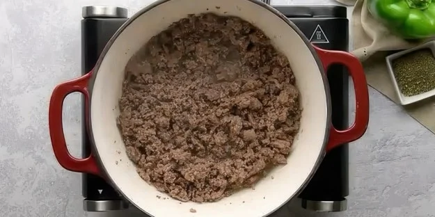 Browned ground beef in Dutch oven.