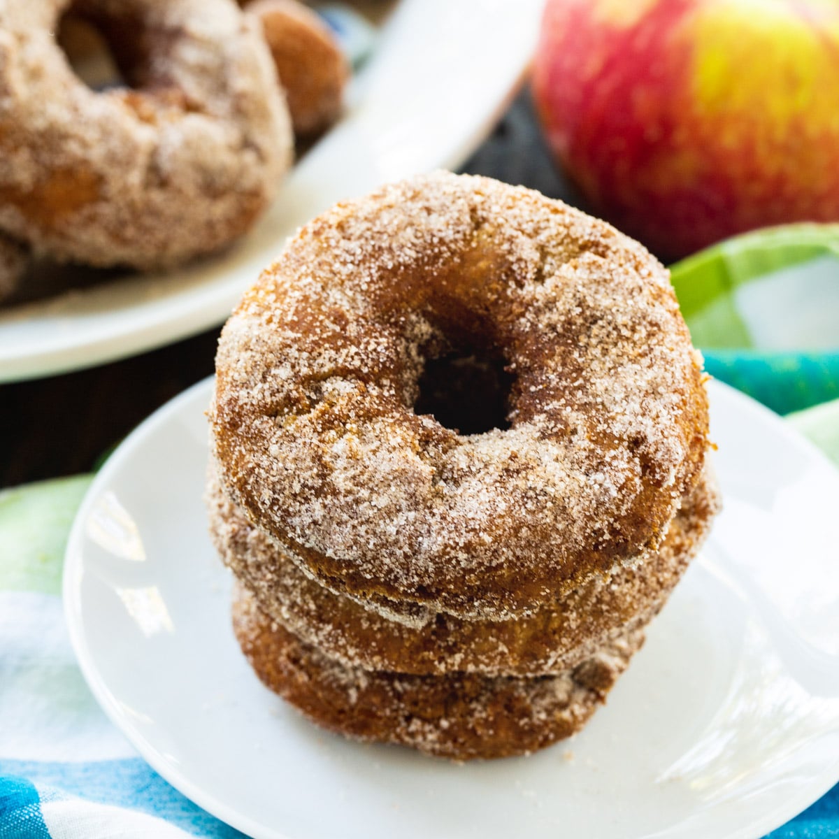 Apple Cider Doughnuts stacked on a plate.