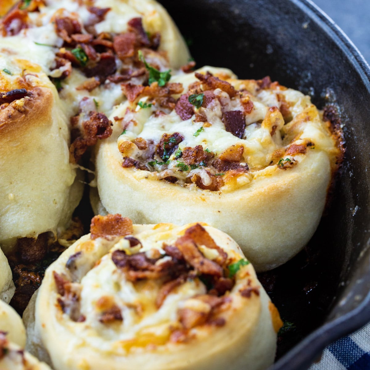 Bacon Stuffed Cheesy Garlic Rolls in a cast iron pan.