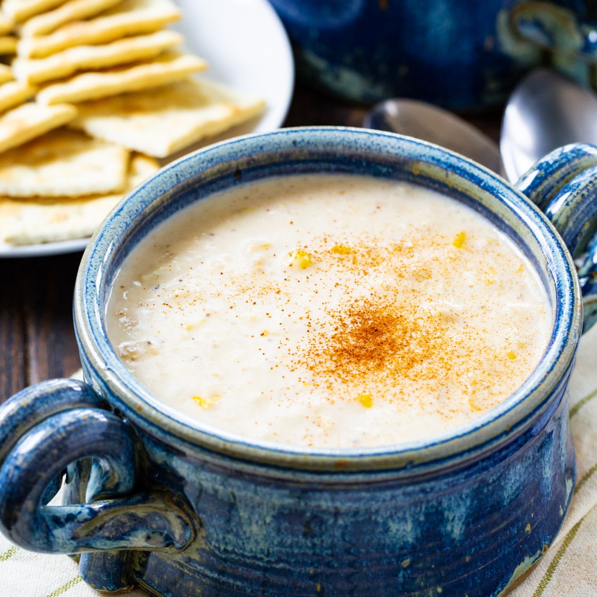 Easy Corn and Crab Chowder in a rustic blue bowl and a plate of saltines.