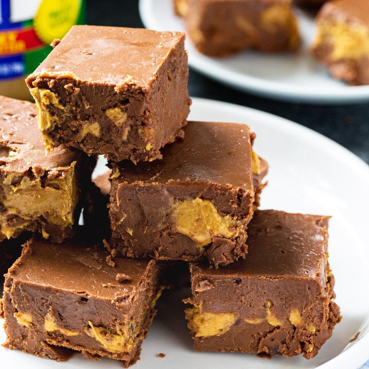 Chocolate Peanut Butter Fudge stacked on a plate.
