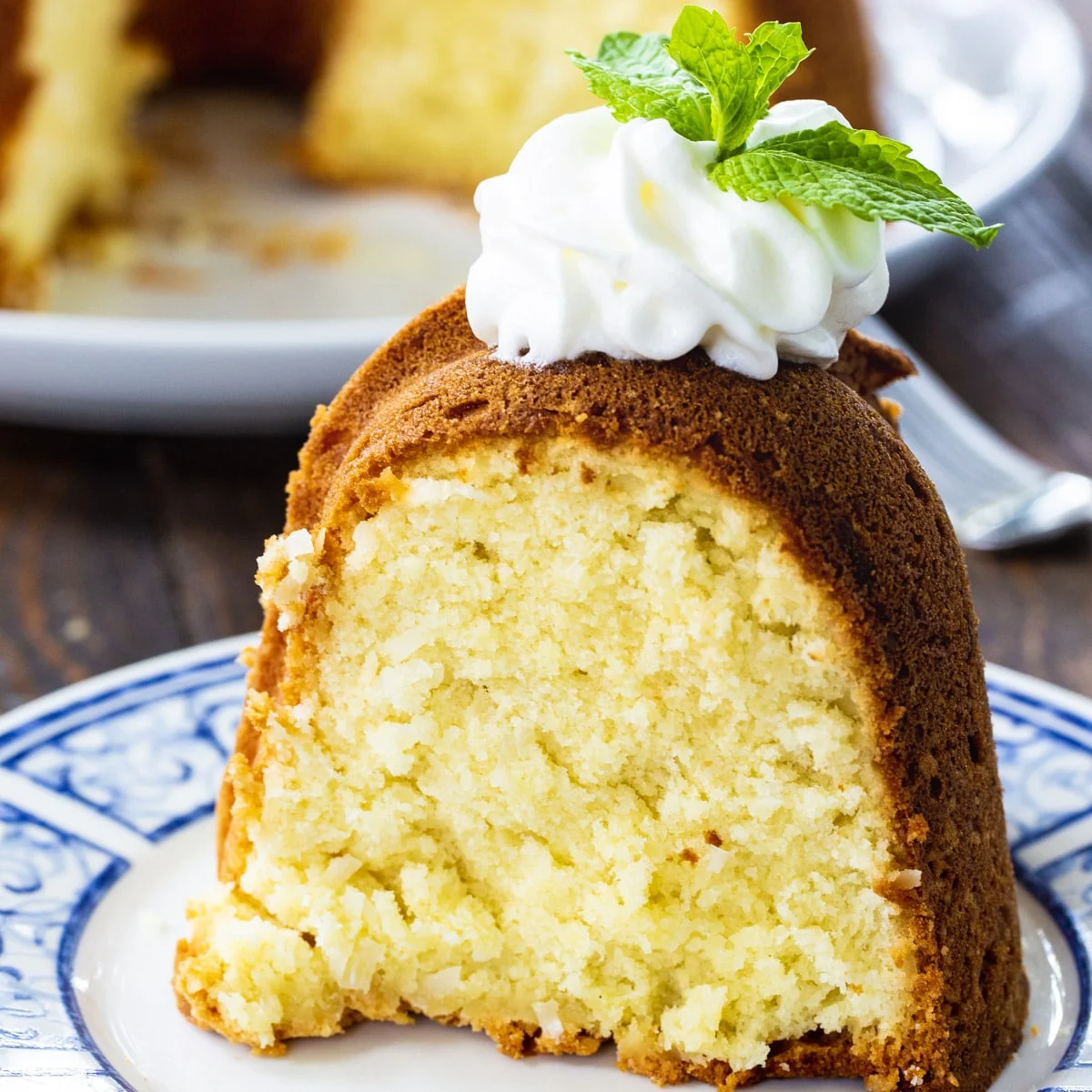 Slice of Coconut Cream Cheese Pound Cake topped with whipped cream.