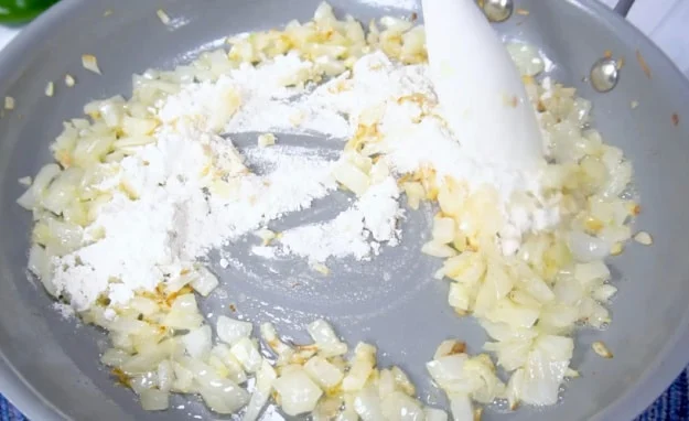 Sprinkling flour over onions.