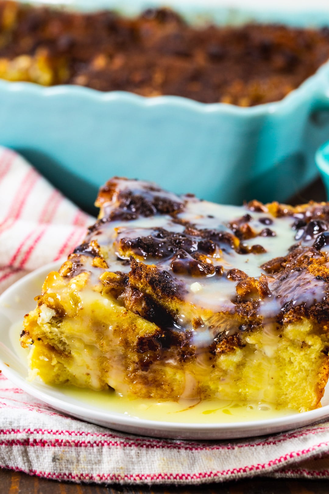 Slice of White Chocolate Bread Pudding on a plate with white chocolate sauce.