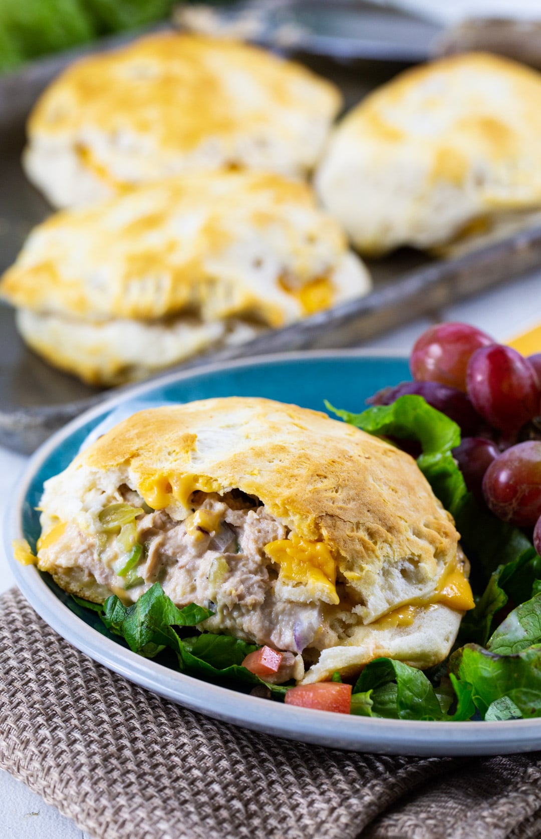 Biscuit Tuna Melt on a platewith red grapes.