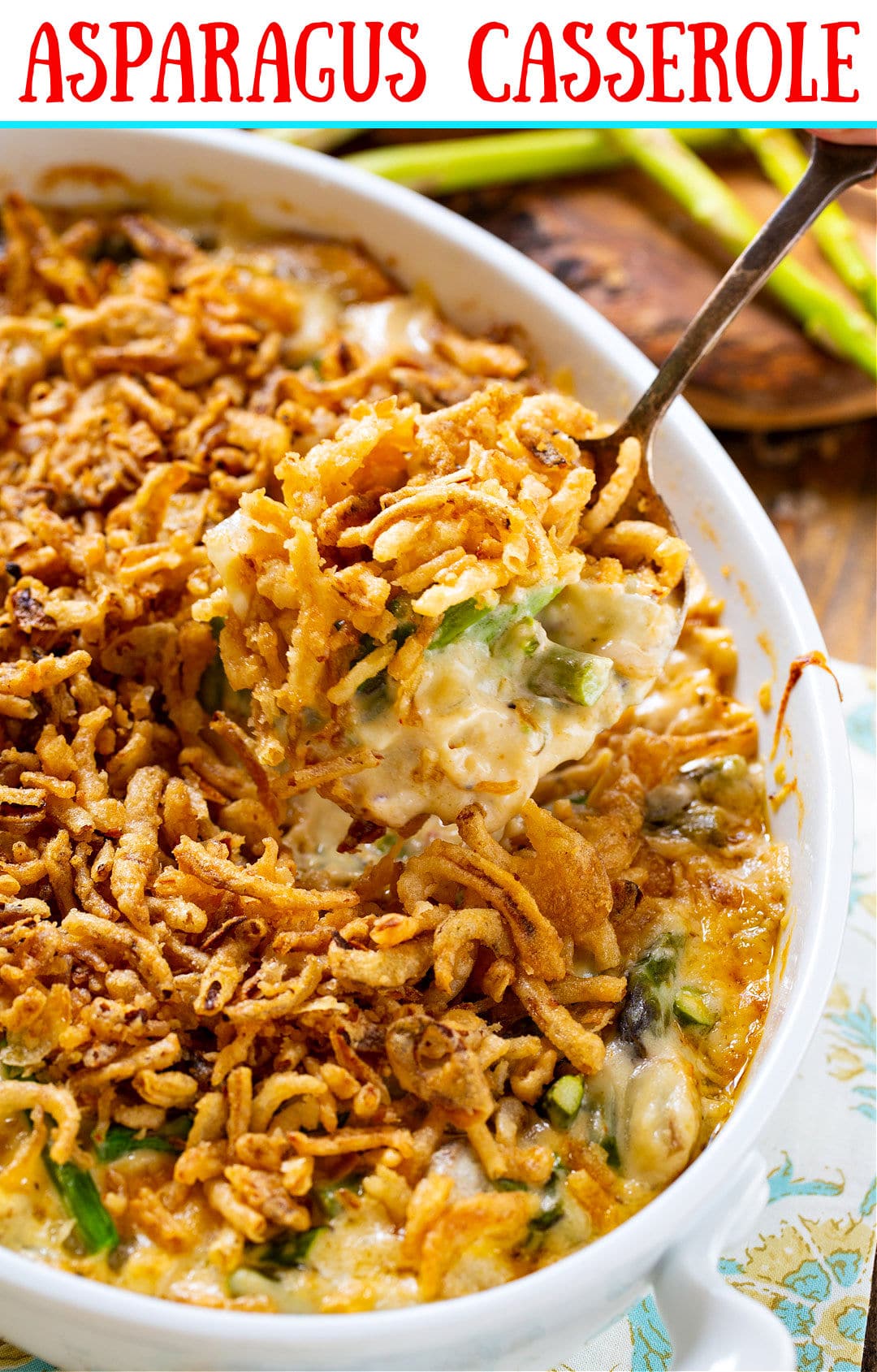 Large spoon scooping Asparagus Casserole out of baking dish.