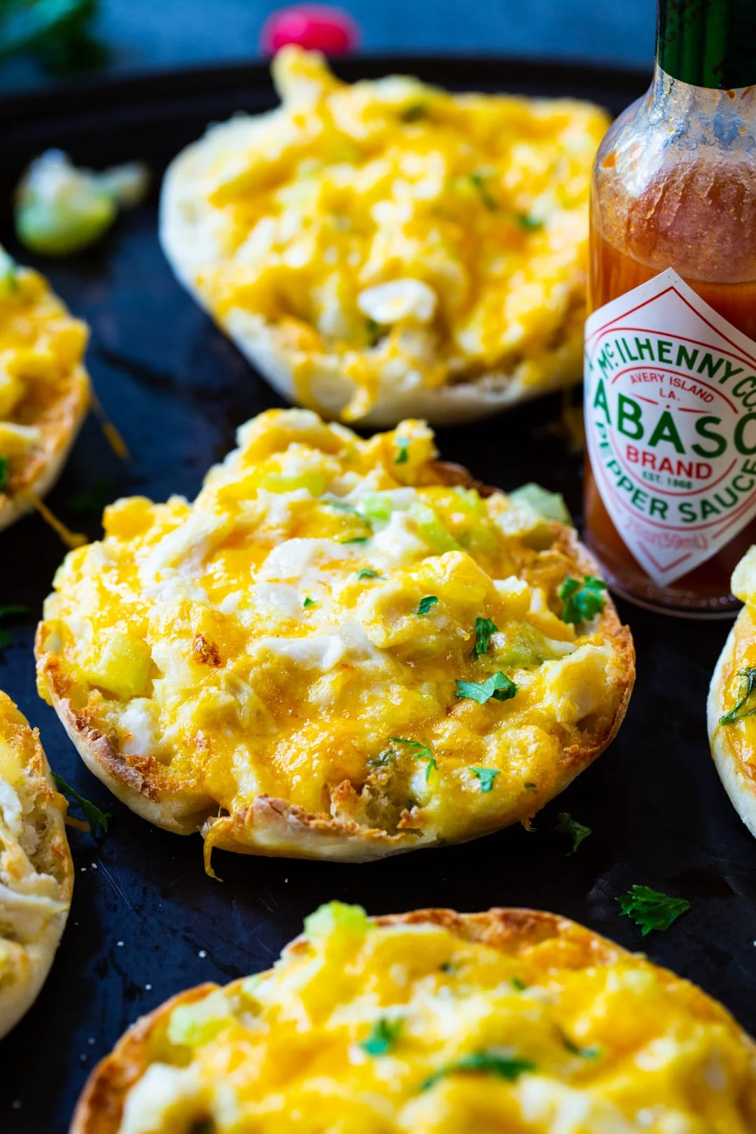 Crab Melts and bottle of Tabasco on baking sheet.