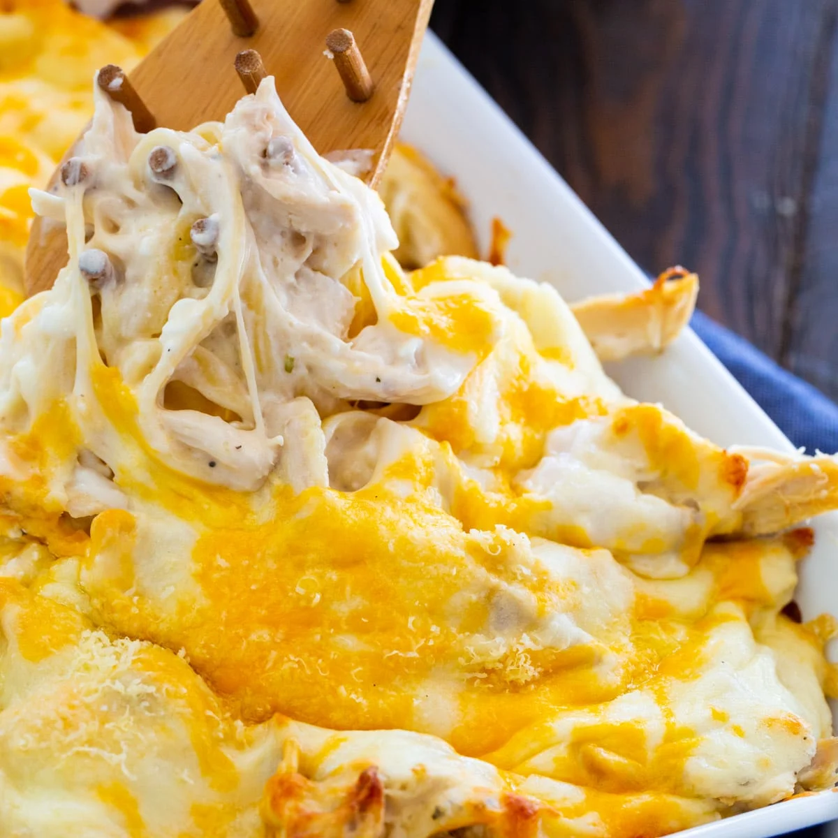 Million Dollar Chicken Alfredo getting scooped out of backing dish.