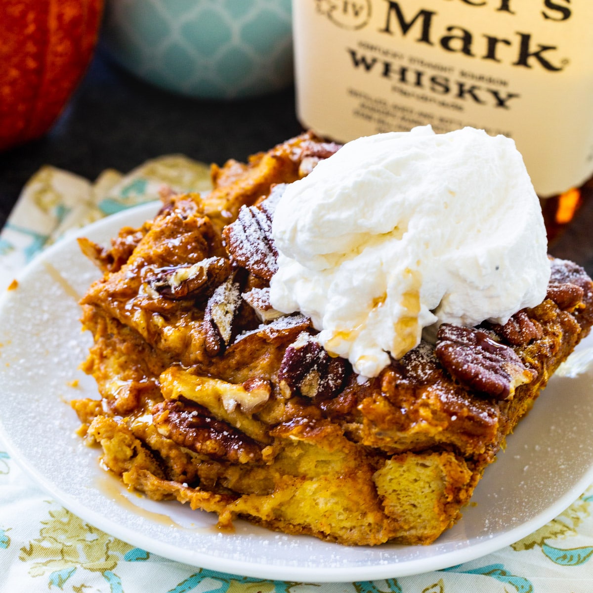 Slice of Pumpkin Bread Pudding topped with whipped cream.