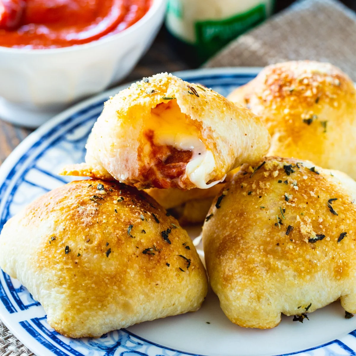 Stuffed Crust Pizza Snacks on a plate and a bowl of pizza sauce.