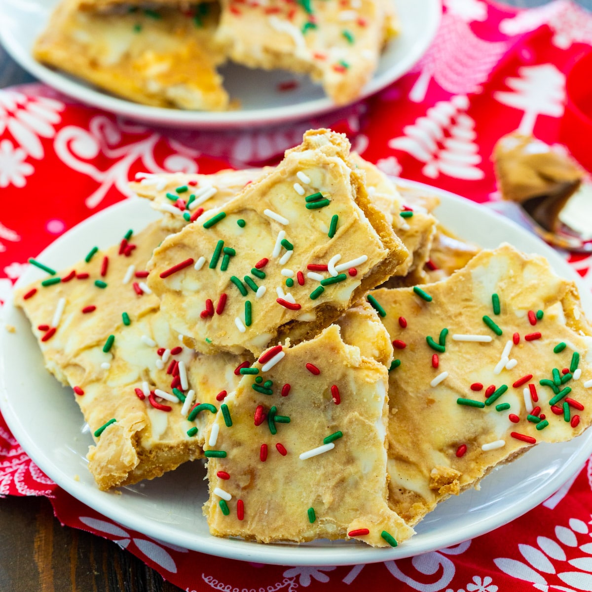 Pieces of White Chocolate and Peanut Butter Crack piled up on a plate.