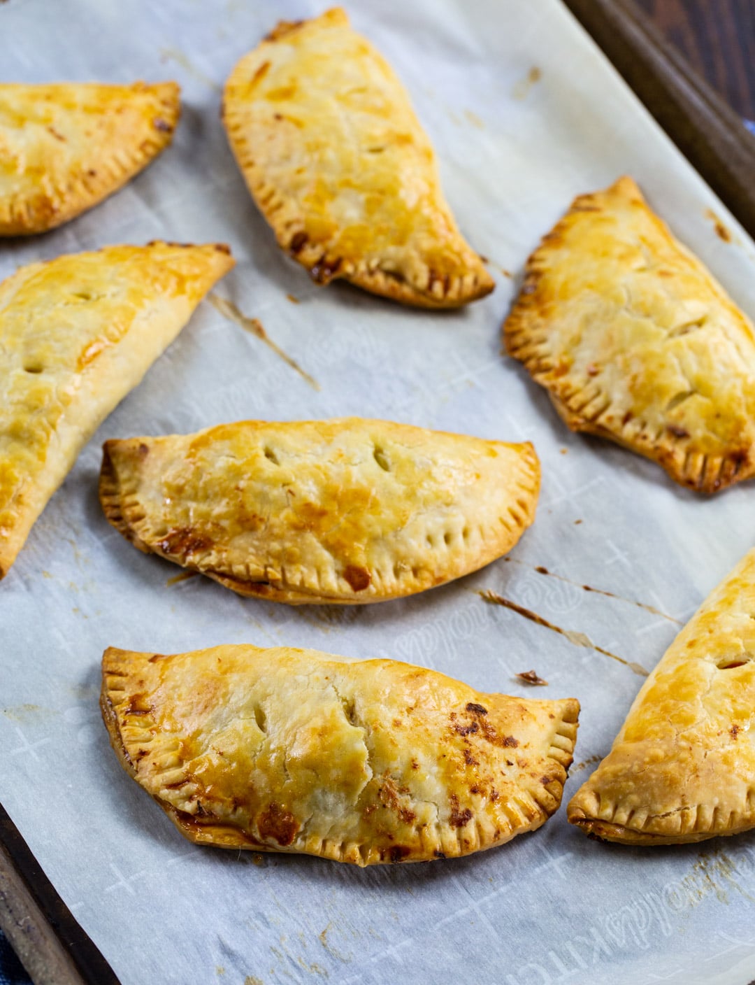 Creamy Chicken Hand Pies on parchment paper-lined bakig sheet.