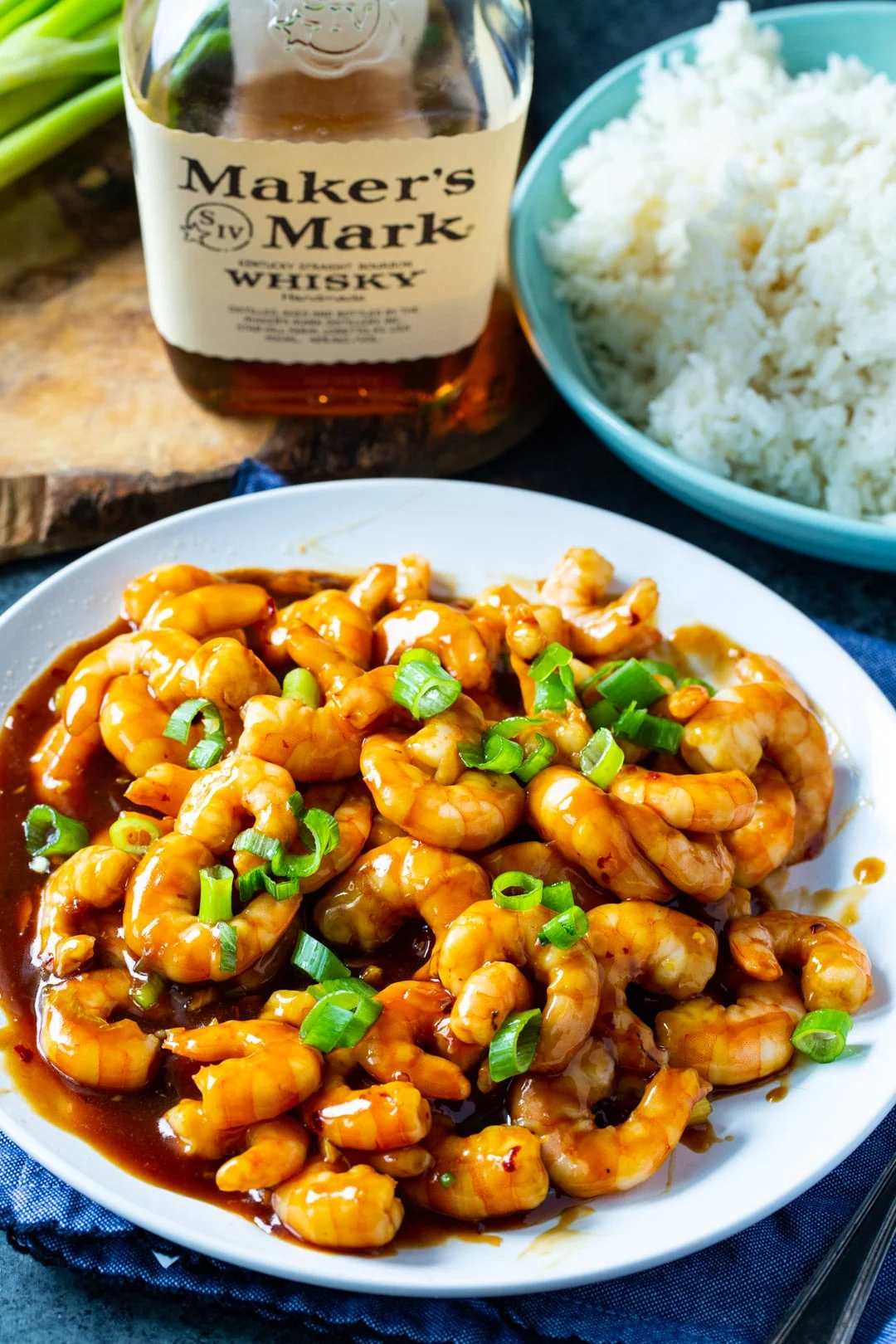 Bourbon Shrimp on a plate and bottle of bourbon.