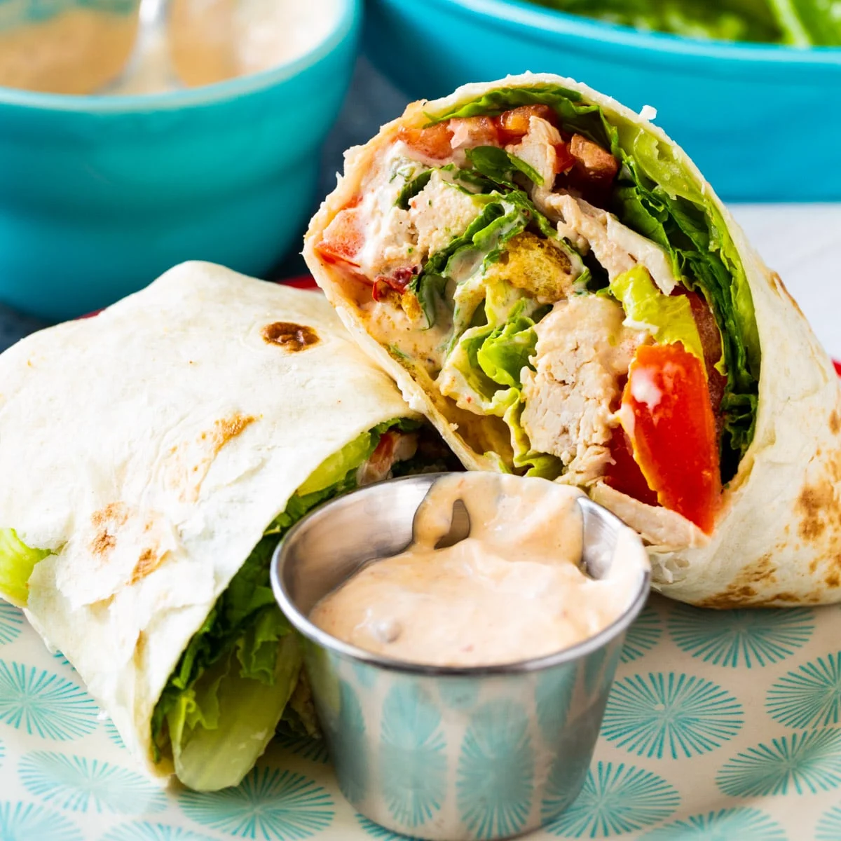 Cut in half Spicy Chicken Caesar Salad Wrap on a plate.