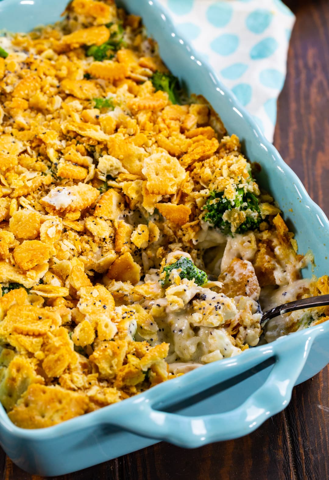 Poppy Seed Casserole in baking dish with spoon.