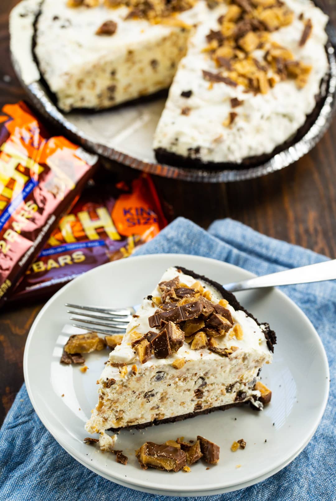 Slice of pie on small plate and rest of pie in background.
