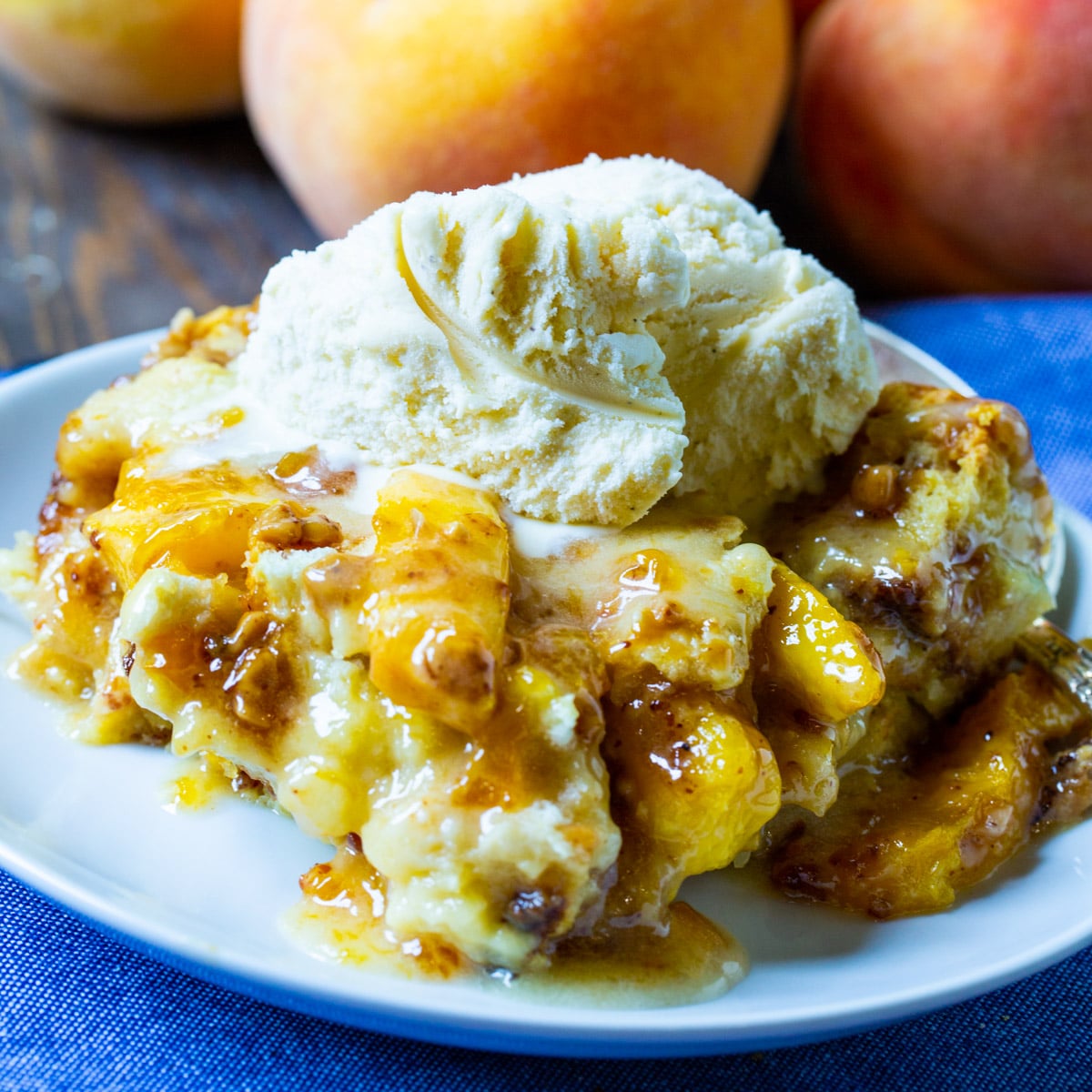 Piece of Cinnamon-Peach Bread Pudding topped with ice cream on a plate.