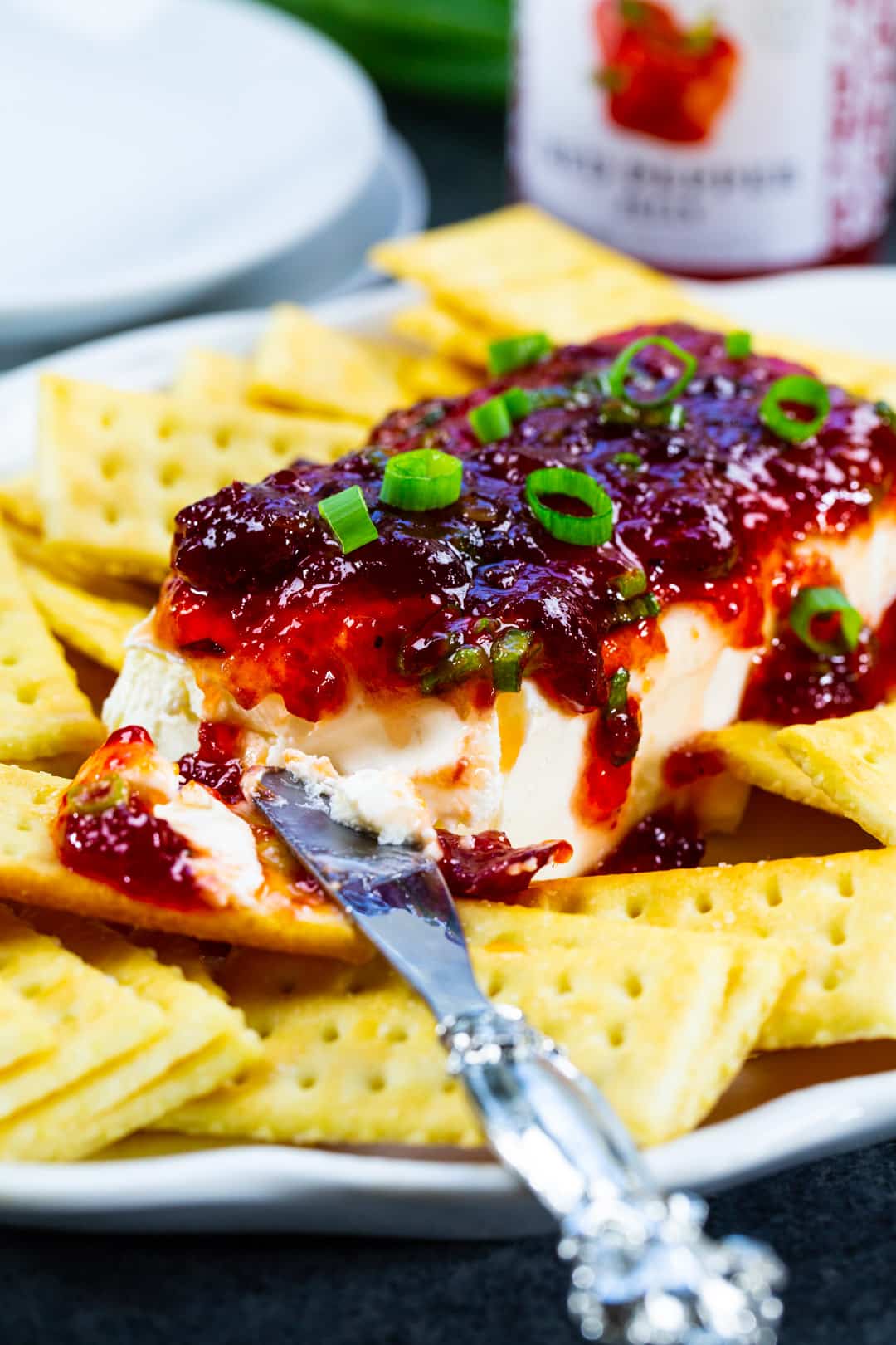 Knife cutting into Cranberry Pepper Jelly Spread.