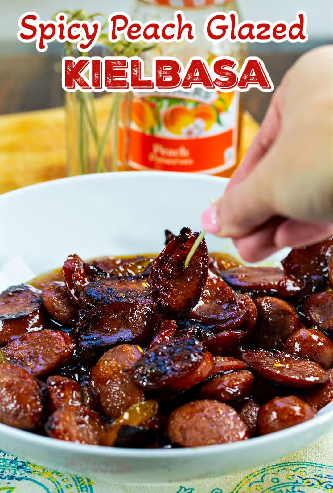 Toothpick picking up piece of glazed sausage.