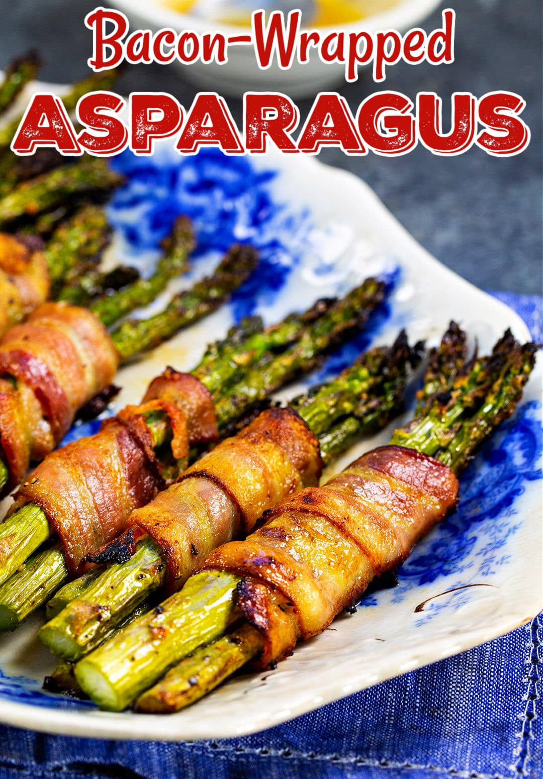 Bacon Wrapped Asparagus lined up on a plate.