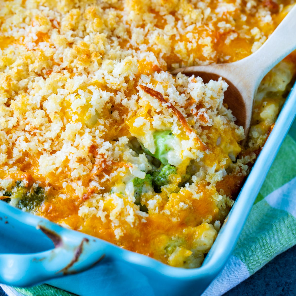 Spoon scooping casserole out of baking dish.