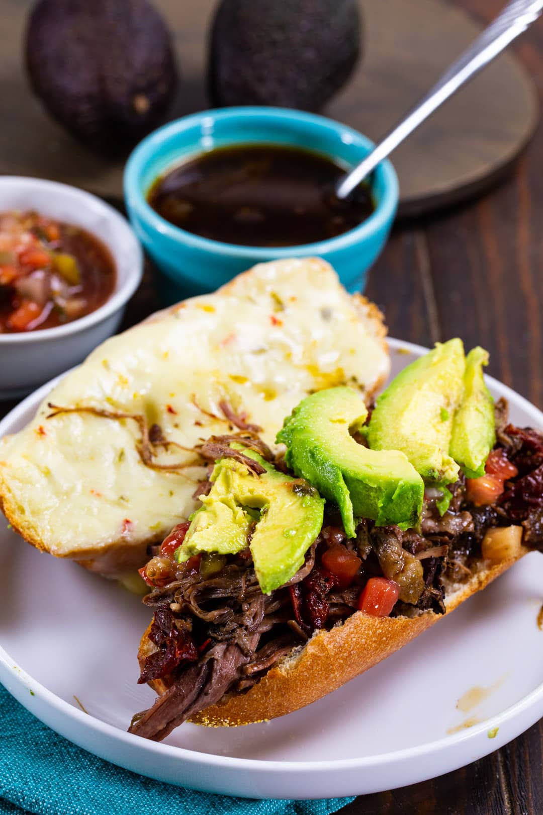 Sandwich on a plate and a bowl of Au Jus.