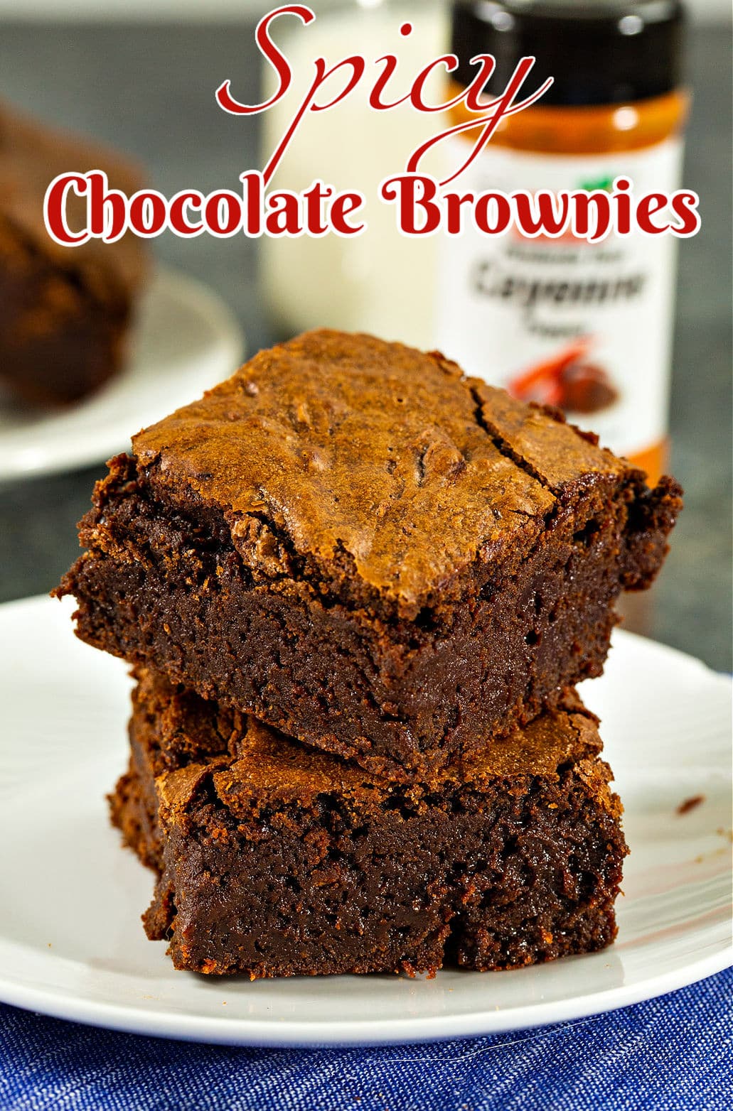 Two brownies stacked on a plate.