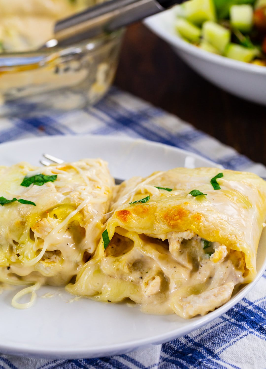 Two Chicken Alfredo Lasagna Roll-Ups on a plate.