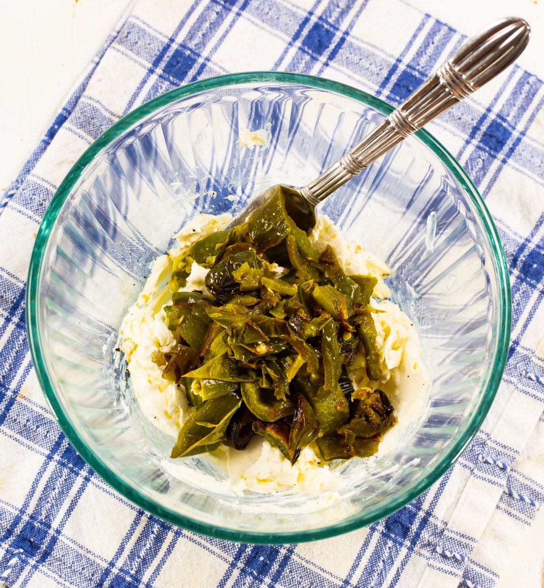 Cream cheese and roasted jalapenos in mixing bowl.