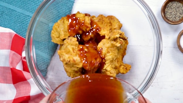 Pouring the sauce over chicken.