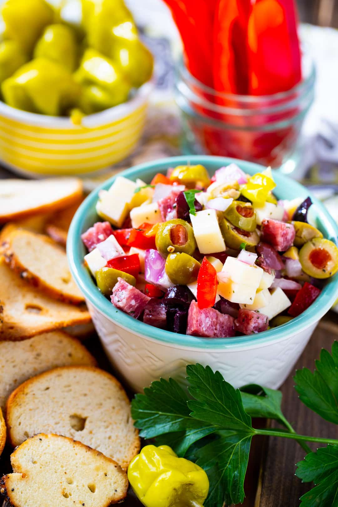 Dip in a small bowl surrounded by chips and fresh vegetables.