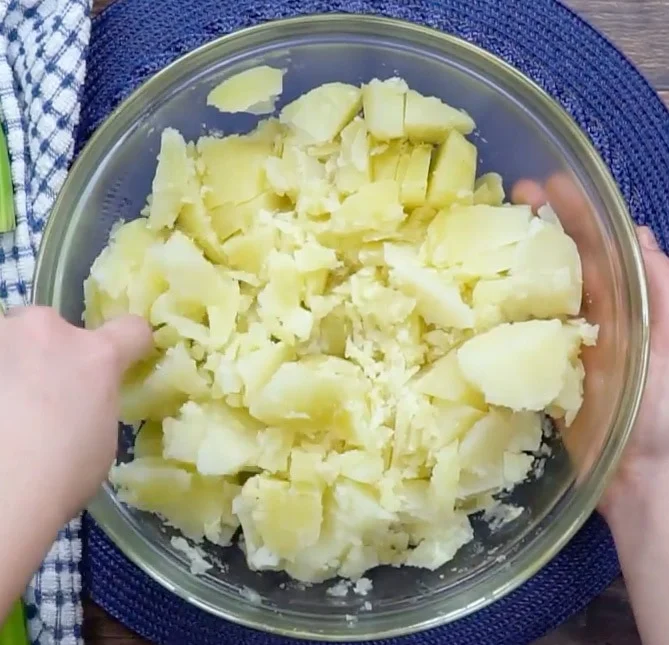 Cutting up cooked potatoes.