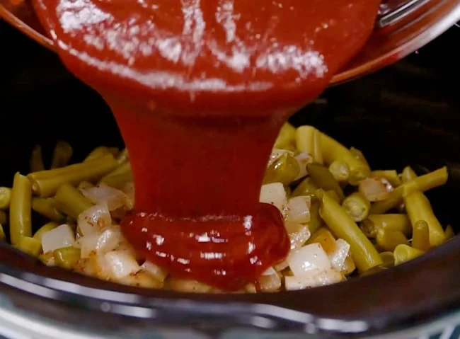 Pouring ketchup mixture into slow cooker.