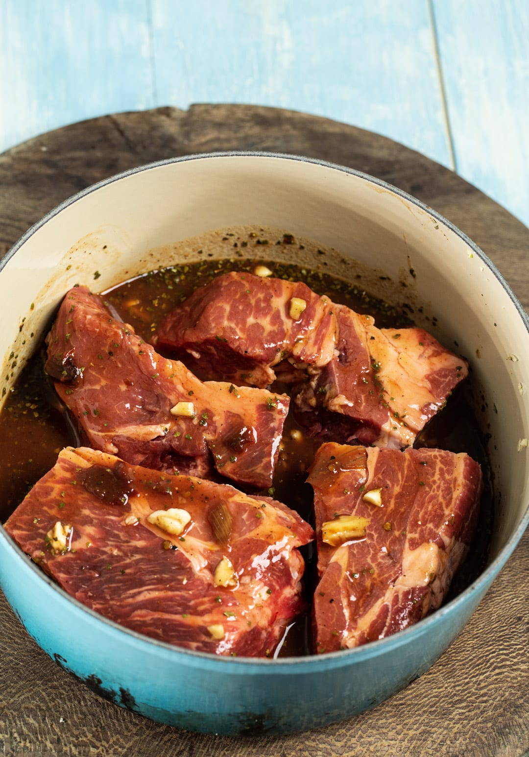 Uncooked chuck roast coated in sauce.