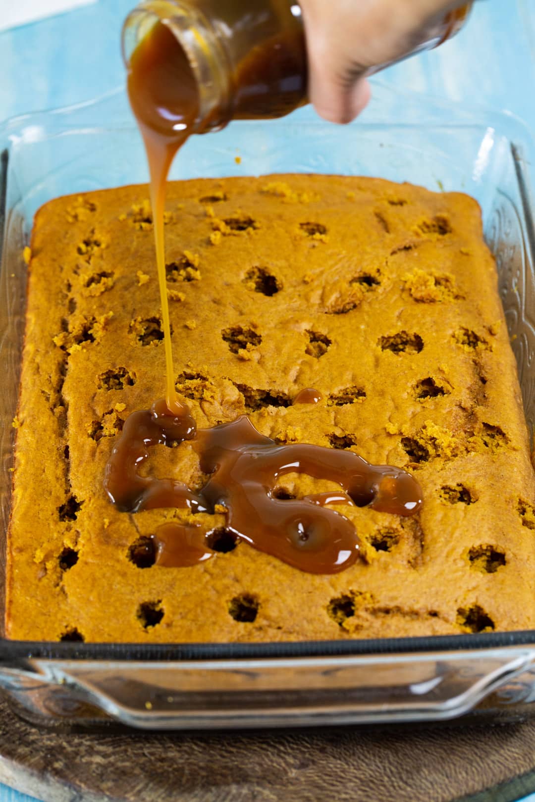 Pouring caramel sauce into holes.