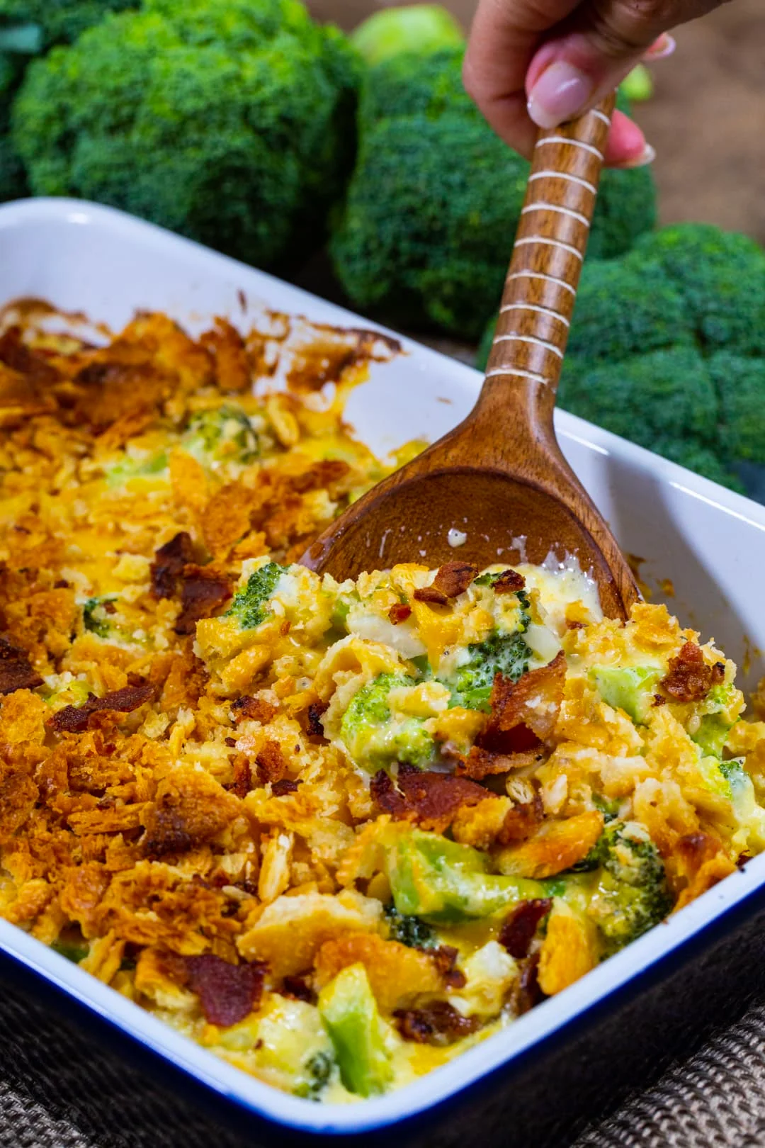Wooden spoon scooping Loaded Broccoli Casserole.