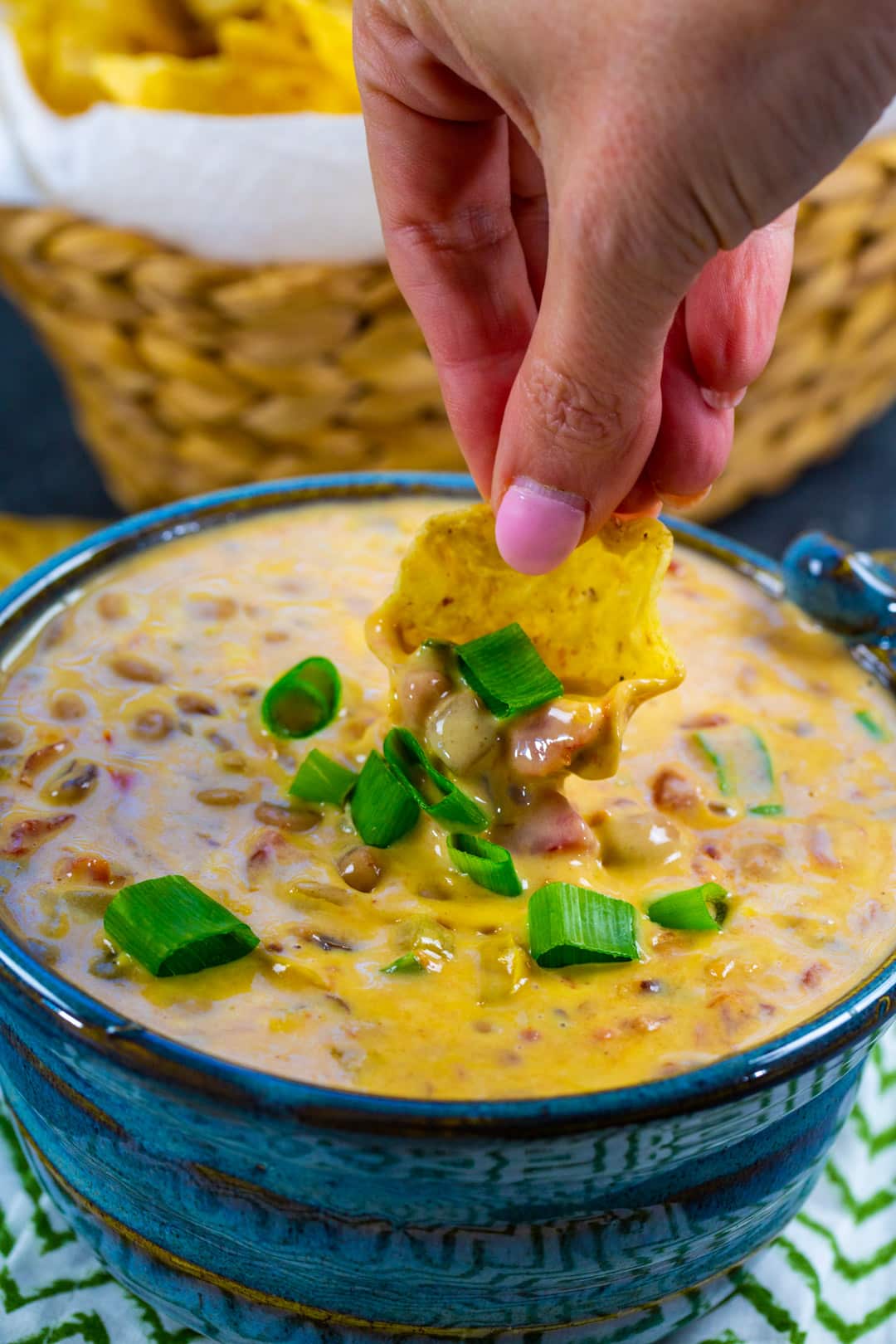 Hand dipping chip into Slow Cooker Black-Eyed Pea Dip.