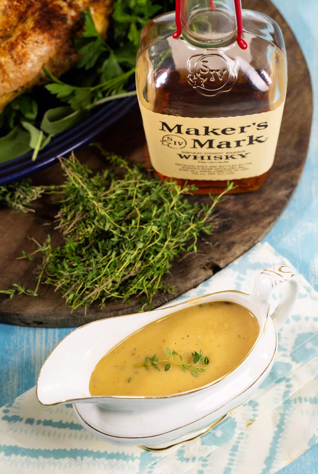 Gravy in a gravy boat and a bottle of bourbon.