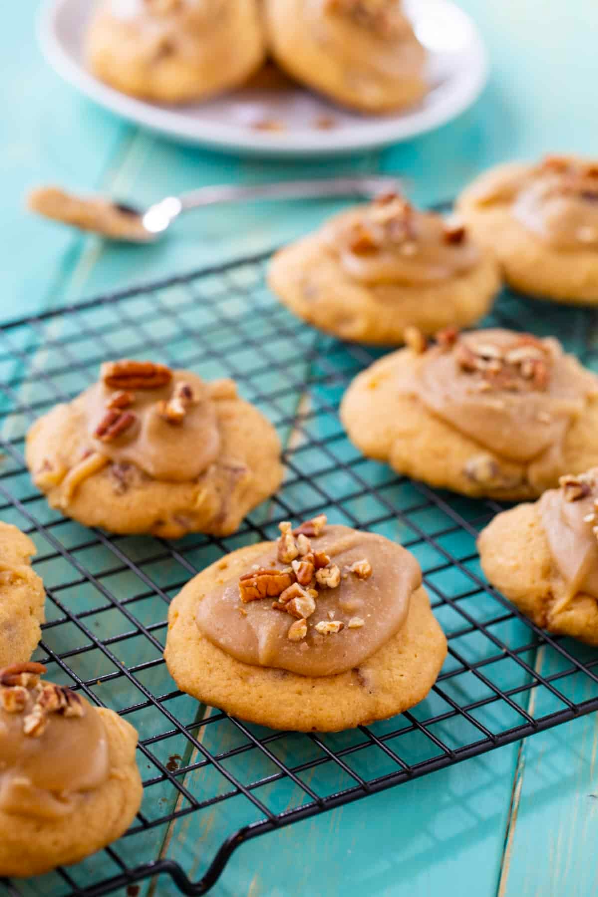 Frosted cookies on a wire rack.