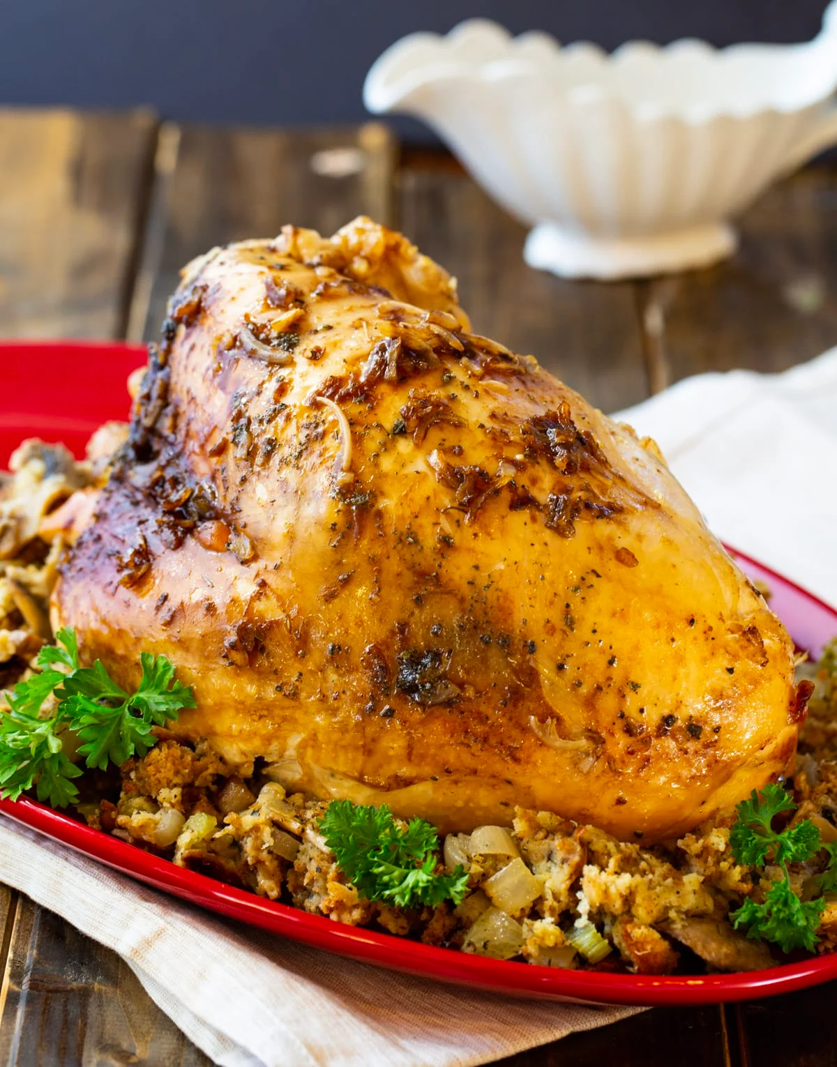 Whole turkey breast on top of stuffing on a platter.